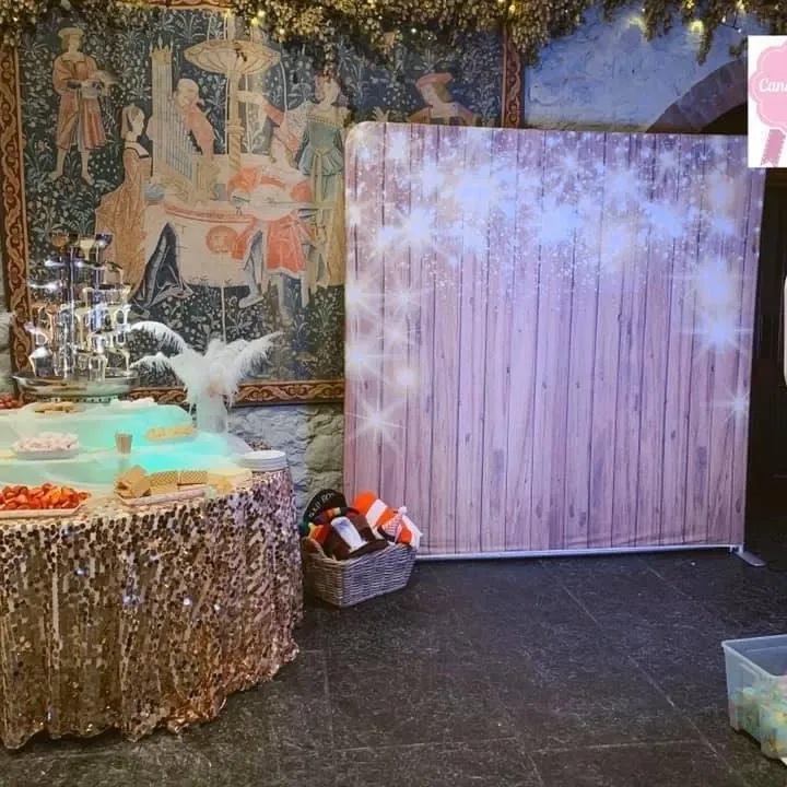 Photo booth backdrop with a props table at a party
