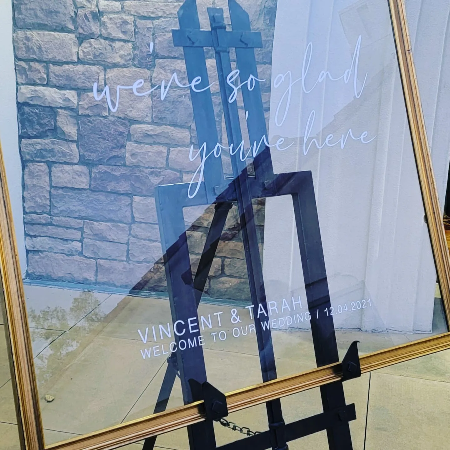 Calligraphed wedding welcome sign on a gold easel