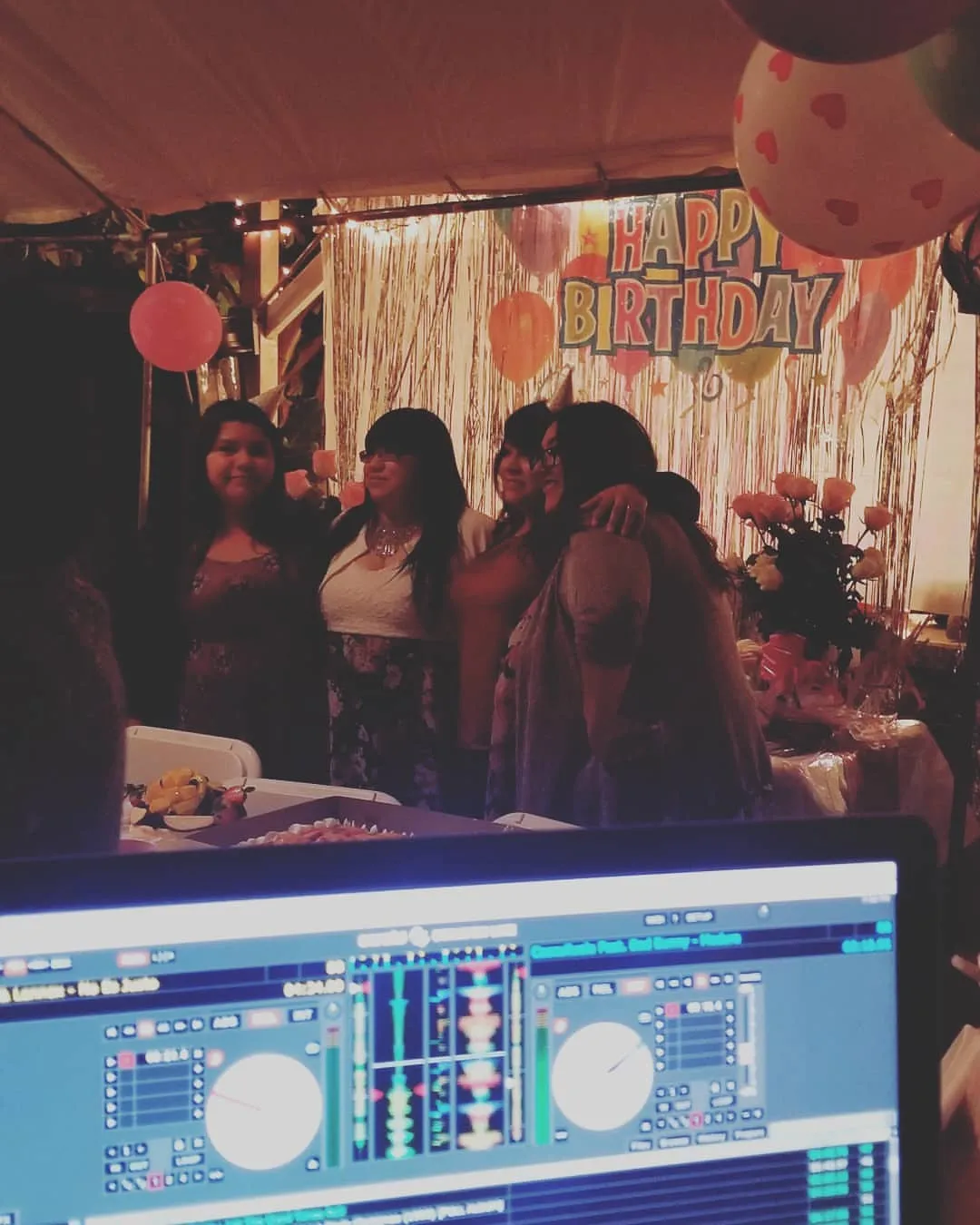 Guests dancing at a birthday party behind the DJ screen