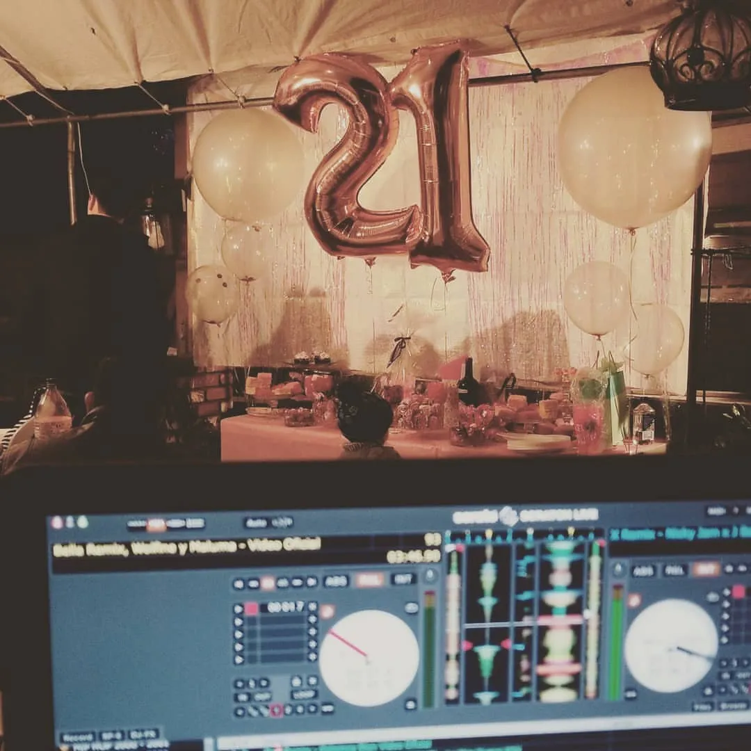 Giant 21 balloons above a DJ controller at a birthday party