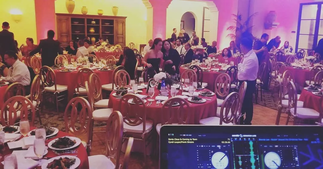 Full banquet room of guests seen from behind the decks