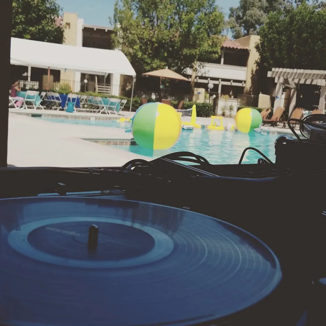 Pool party DJ setup with beach balls on the water