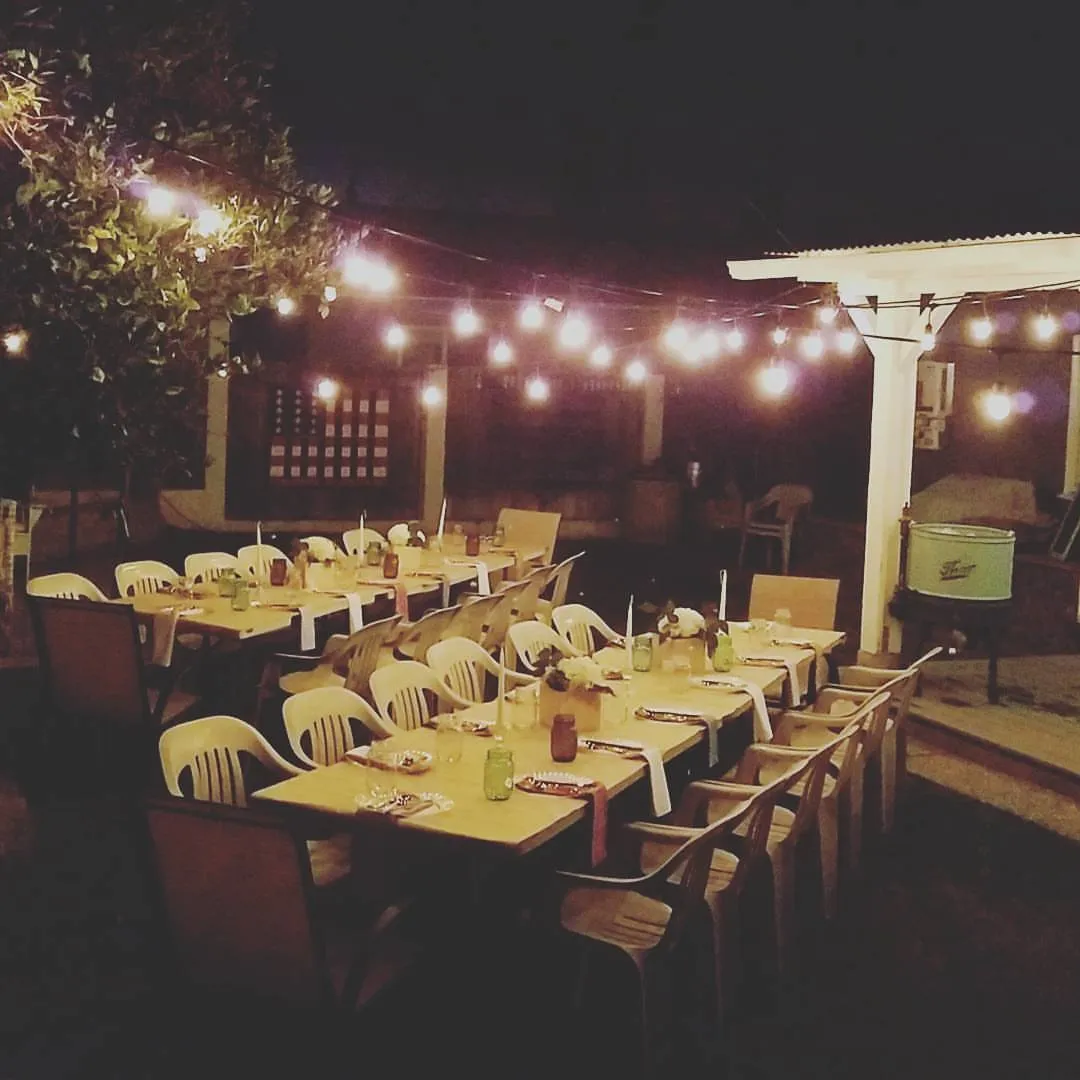 Patio tables under strings of café lights before guests arrive