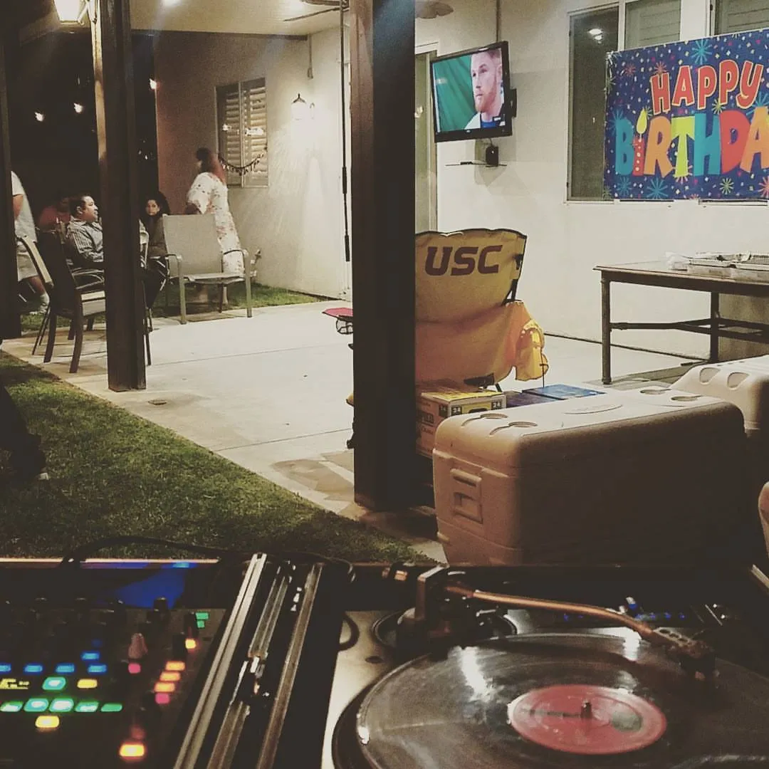 Backyard birthday party at dusk behind a turntable