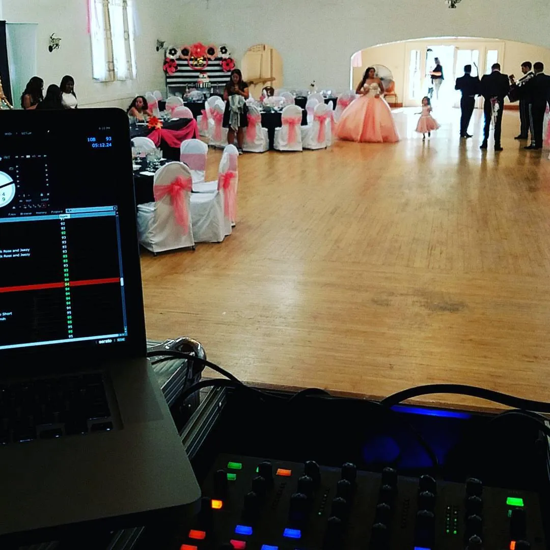 Quinceañera in a ballgown on the dance floor beyond the DJ screen