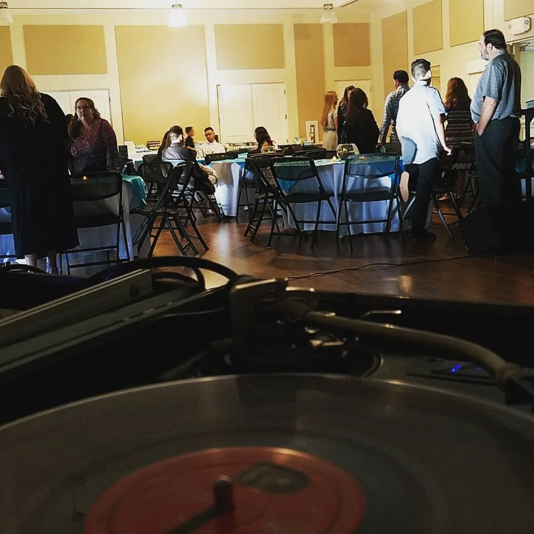 Event hall filling up, seen across a spinning record